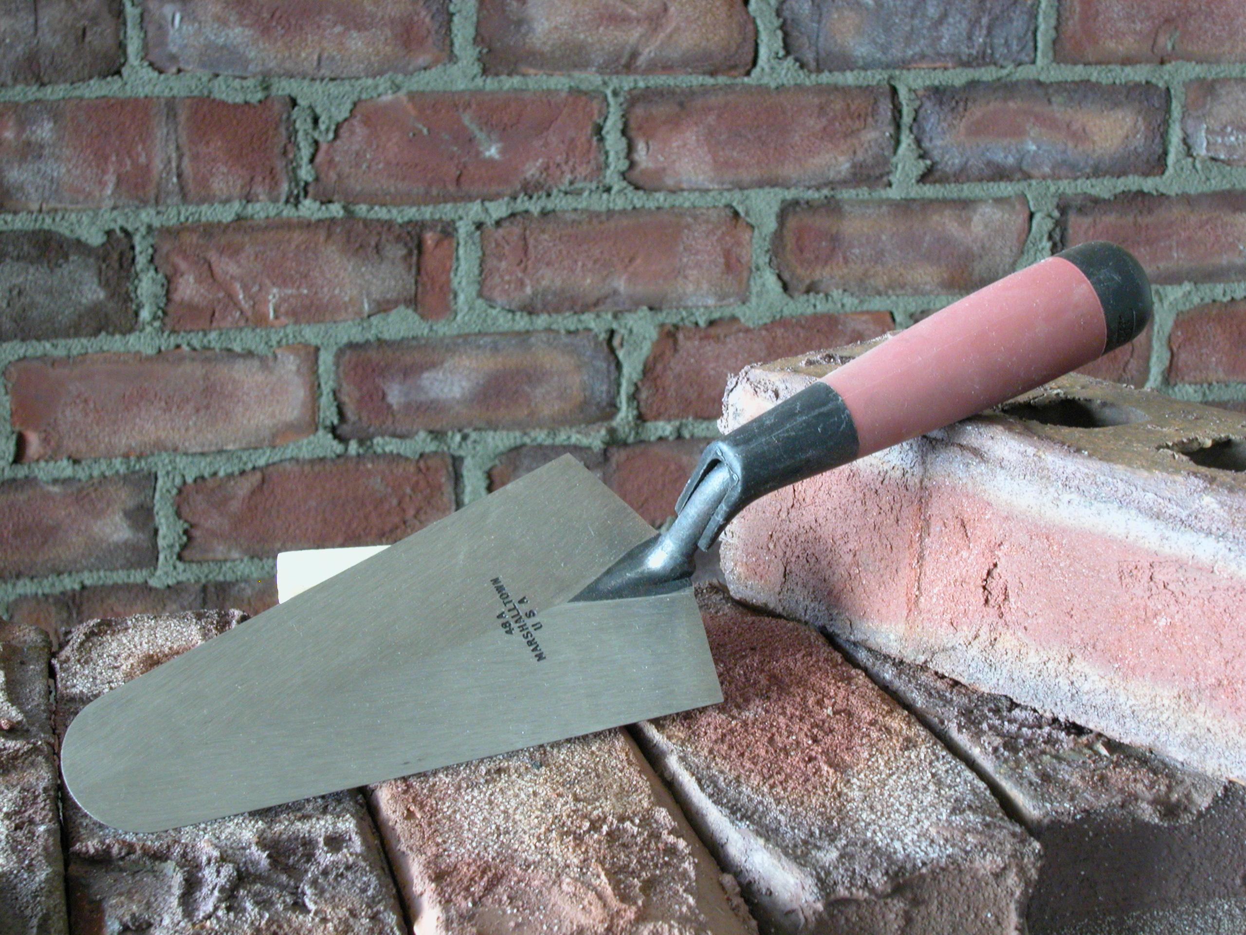 a MARSHALLTOWN Gauging Trowel next to a brick
